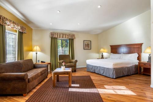 ein Hotelzimmer mit einem Bett und einer Couch in der Unterkunft Oak-Lodge - Roundhouse Resort and Spa in Indian Pine