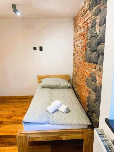 een bed in een kamer met een bakstenen muur bij Skansen- Bożejów in Radomierowice