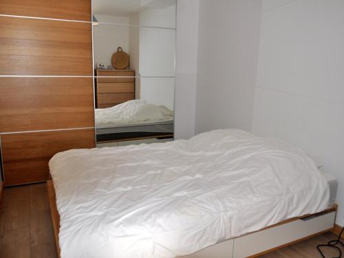a white bed in a room with a mirror at Appartement avec Terrasse et Parking Privé à La Chapelle-d'Abondance - FR-1-692-3 in La Chapelle-dʼAbondance