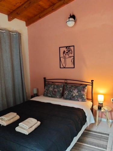 a bedroom with a bed with two towels on it at FELINA HOUSE in Artemida