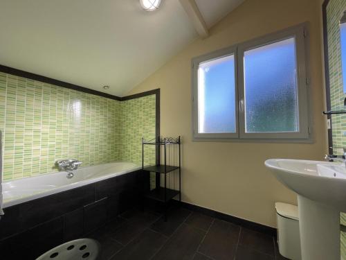 ein Badezimmer mit Badewanne und Waschbecken in der Unterkunft Ohiana in Villefranque