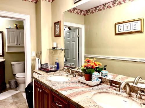 a bathroom with two sinks and a large mirror at Barker House 3# Suite-heart of oldtown in Niagara on the Lake