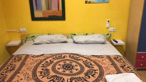 a bed in a room with two pillows on it at Casa con encanto con perritos in San Juan de Alicante