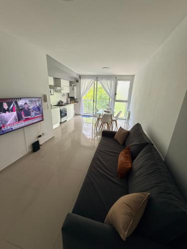 Una sala de estar con un sofá y un televisor. en Las Lomitas Torre London, en Lomas de Zamora
