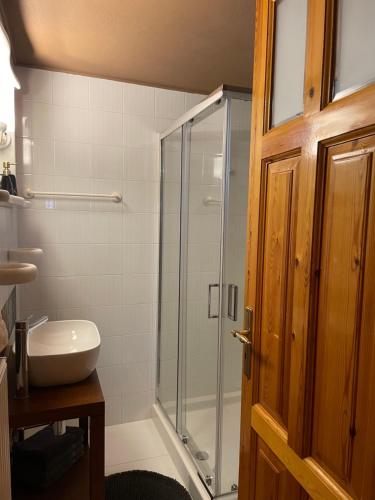 een badkamer met een glazen douche en een wastafel bij Capris Rustic Ηouse with Mountain View in Archaia Feneos