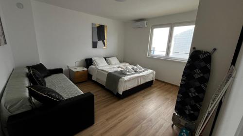 a small bedroom with a bed and a couch at Anna apartman in Niš