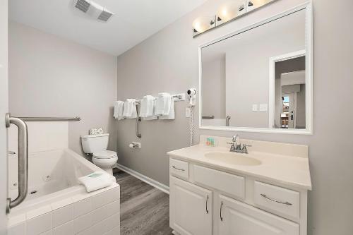 une salle de bain avec un lavabo, des toilettes et un miroir dans l'établissement Club Ocean Villas II, à Ocean City