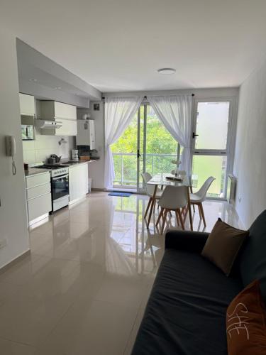 Una cocina y una sala de estar con un sofá y una mesa. en Las Lomitas Torre London, en Lomas de Zamora