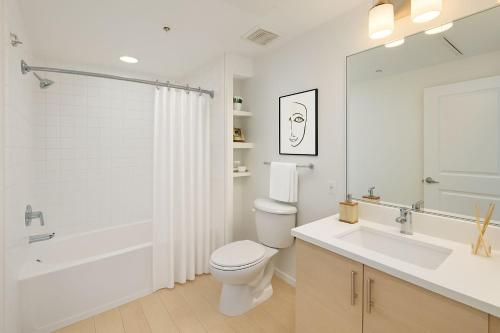 een witte badkamer met een toilet, een bad en een wastafel bij Park City Suite in Park City