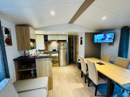 a kitchen and dining room with a table and chairs at Mobil home 6 à 8 personnes in Piriac-sur-Mer