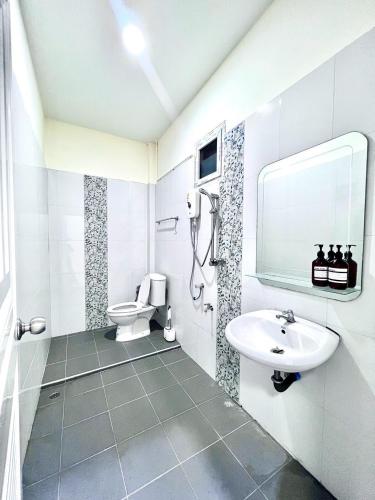 a white bathroom with a sink and a toilet at I'm Home Narathiwat in Narathiwat
