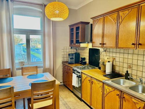 eine Küche mit Holzschränken und einem Tisch mit Spüle in der Unterkunft Kawka i herbatka in Zielona Góra