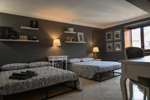 Un dormitorio con dos camas y una mesa y un escritorio. en Casa Via Po, en Turín