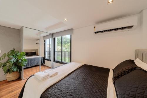 a bedroom with a large bed and a large window at Compact Loft Residencial Flipchave CLO000 in Boa Vista