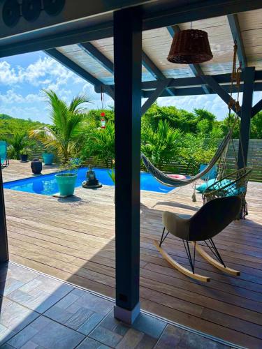 a patio with a hammock and a swimming pool at Bel Kay in Rivière-Salée