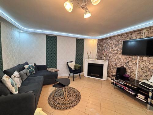 a living room with a couch and a tv at Cazare La Luiza in Şura Mare