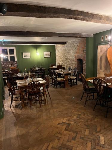 een eetkamer met tafels en stoelen en een bakstenen muur bij The Bath Arms Shearwater in Warminster