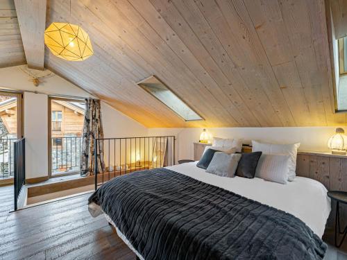a bedroom with a large bed with a wooden ceiling at Chalet moderne avec parking et wifi, à proximité des pistes et commerces - FR-1-566-20 in Les Allues