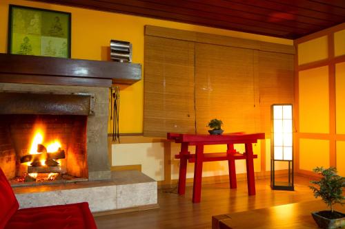 a living room with a fireplace and a table at Hotel Matsubara in Campos do Jordão