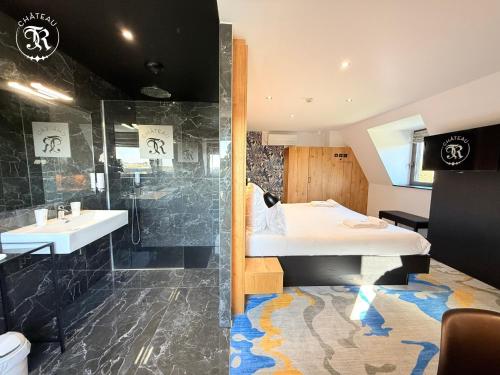 a bathroom with a bed and a shower and a sink at CHATEAU R in Wettolsheim