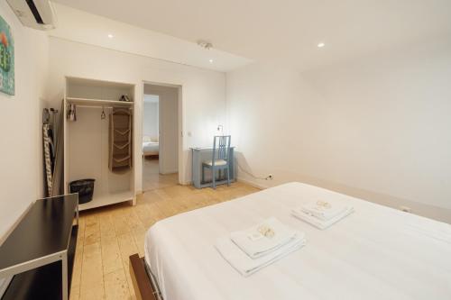 a white room with a bed with towels on it at Porto Window Terrace House by Vacationy in Bandeira