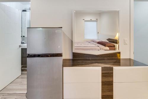 a kitchen with a refrigerator and a bed at Work and Play! North Hills Studio 15 Mi to Hollywood in North Hills