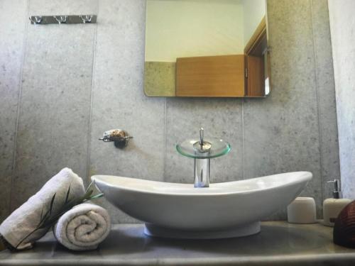 une salle de bain avec un lavabo et un miroir dans l'établissement Sunset Aura Santorini, à Éxo Goniá