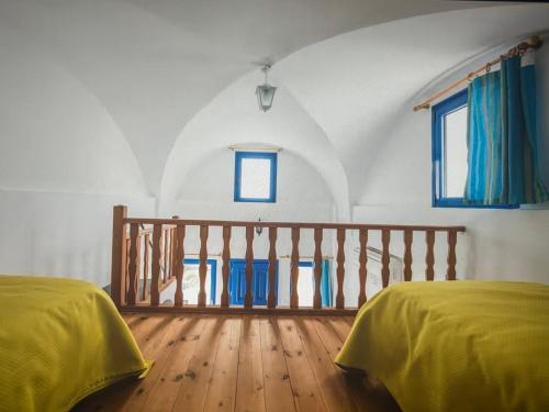 une chambre avec deux lits et un balcon dans l'établissement Sunset Aura Santorini, à Éxo Goniá