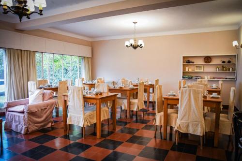ラ・クンブレにあるHostería La Viñaのチェッカーフロアのダイニングルーム(テーブル、椅子付)