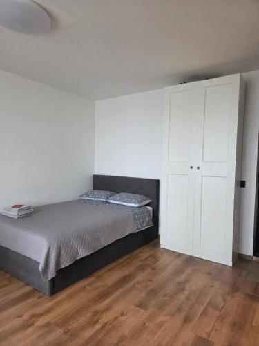 a bedroom with a bed and a white cabinet at Panorama studio in Klaipėda - self check in in Klaipėda