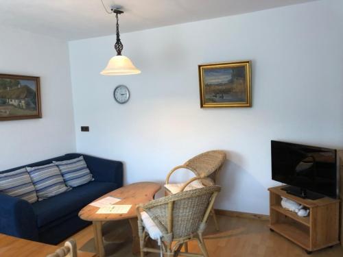 a living room with a blue couch and a table at Ferienwohnung EG rechts in Süderende