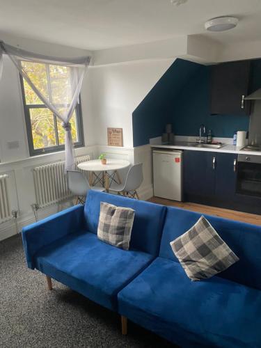 un divano blu in soggiorno con cucina di Blissfull dreams 1 bedroom apartment a Hull