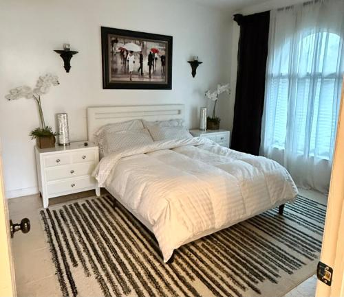 a bedroom with a large white bed and a window at Lux 4 bedroom home on lake with pool! in Coral Springs