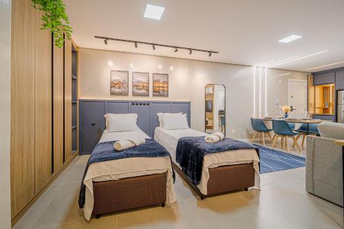 two beds in a room with a kitchen and a dining room at Mingus Residencial Flipchave MIN000 in Joinville