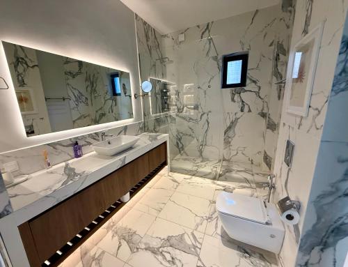 a bathroom with two sinks and a toilet and a mirror at Villa Saguramo in Saguramo