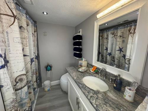 a bathroom with a sink and a toilet at BEACHFRONT OCEANVIEW BALCONY GAMES POOL 75 TV in Cape Canaveral