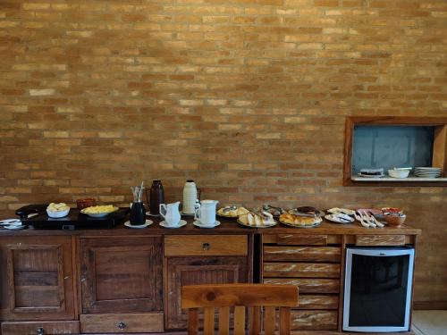 un tavolo con del cibo sopra un muro di mattoni di Pousada dos Pássaros a Santo Antônio do Pinhal
