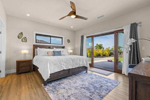 Un dormitorio con una cama y una puerta corrediza de vidrio. en Ainamalu, en Waikoloa