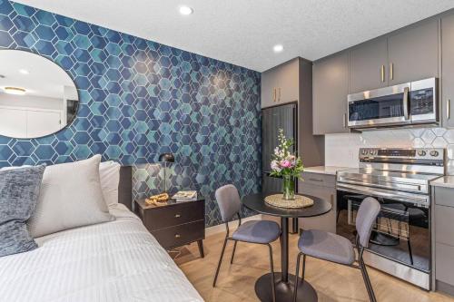 a living room with a bed and a kitchen at Chick and Cozy Haven near Banff with Hot tub and Pool in Canmore