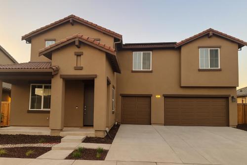 a house with two garage doors at Modern Private Room with Private Bath in Manteca