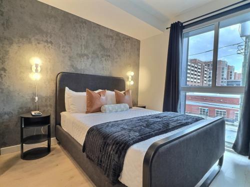 a bedroom with a large bed with a large window at Bham Studio, Gym Access, Steps from Downtown in Birmingham