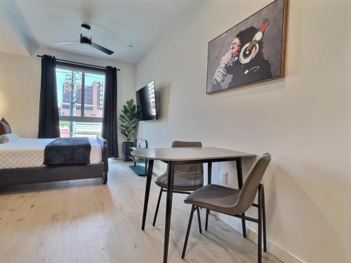 een slaapkamer met een bed, een tafel en stoelen bij Bham Studio, Gym Access, Steps from Downtown in Birmingham