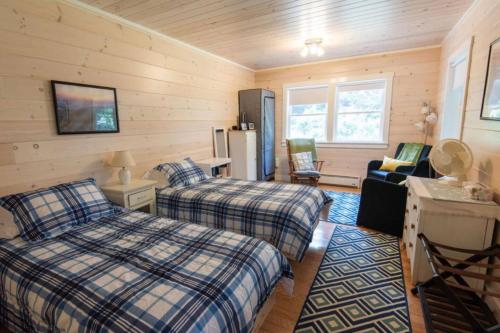 a bedroom with two beds and a refrigerator at Secluded Cabin With Ocean Access in Seal Cove