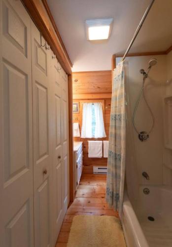 a bathroom with a shower and a bath tub at Secluded Cabin With Ocean Access in Tremont