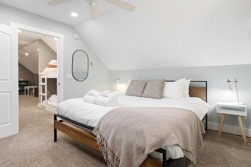 a white bedroom with a large bed and a mirror at The Long Lake Escape in Traverse City