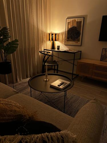 a living room with a table and a couch at BALI apartment in central Mažeikiai SELF CHECK-IN 24H in Mažeikiai