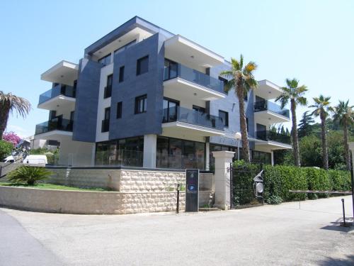 a large building with palm trees in front of it at Apartments Mon Amour in Dubrovnik