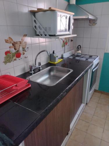 a kitchen with a sink and a stove at Cabañas Los Pinos in Potrero de los Funes