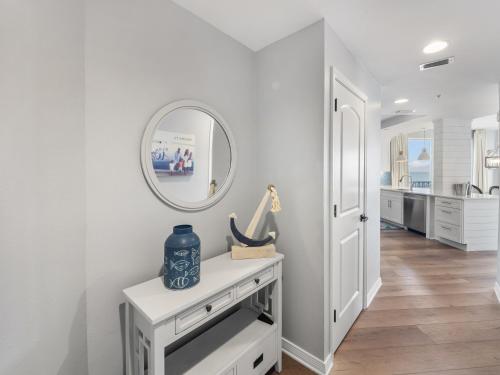 a white hallway with a table and a mirror at Mermaid Manor in Navarre