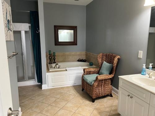 a bathroom with a tub and a chair and a sink at Palmer Room at The Inn, Occano Arnold Palmer Golf 